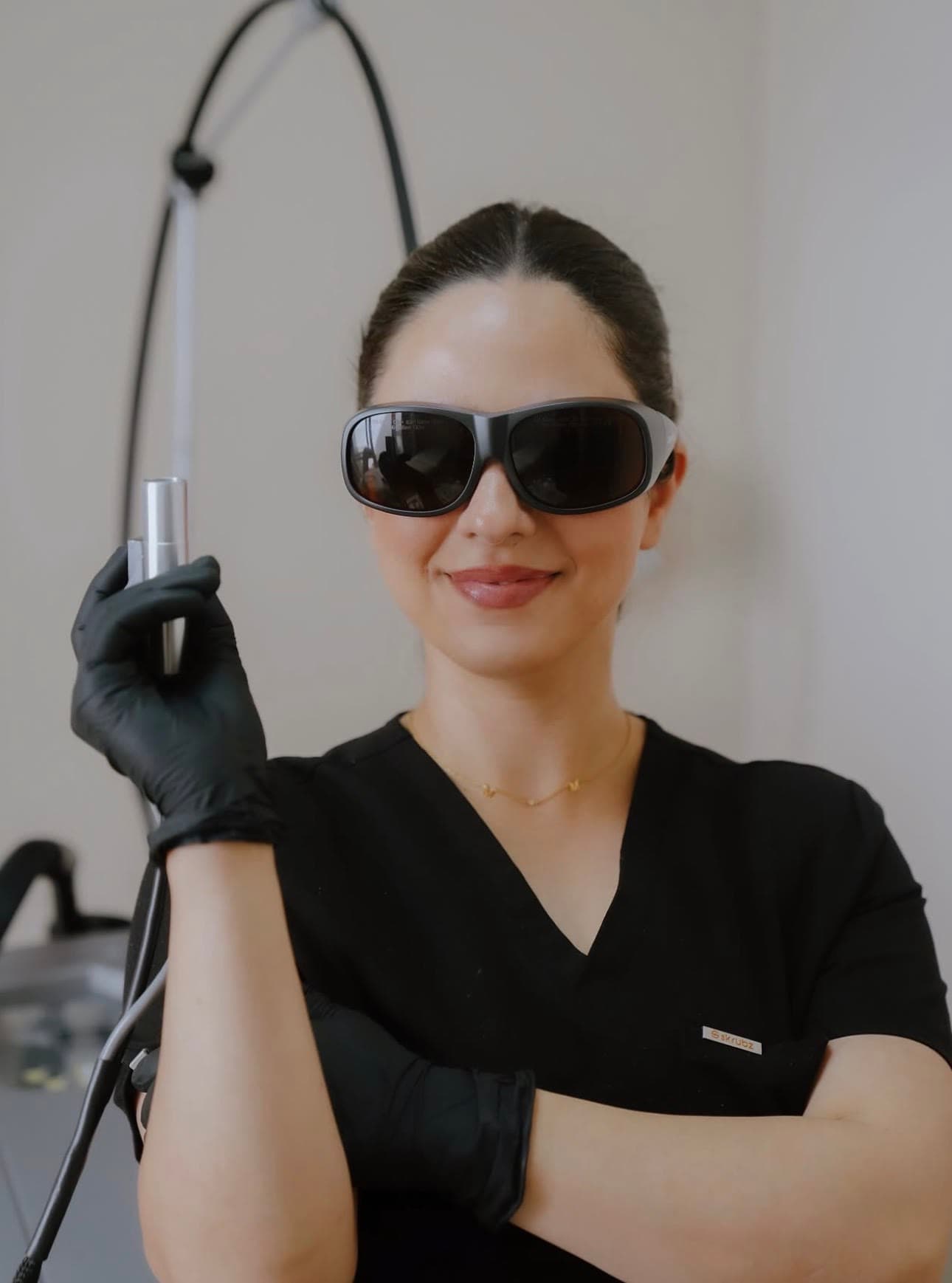 A Lana Aesthetics practitioner in protective laser eyewear, holding the Elite+ handpiece